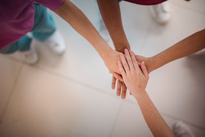 High angle view of kids stacking hands at home