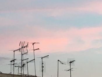 Low angle view of telephone pole against sky during sunset