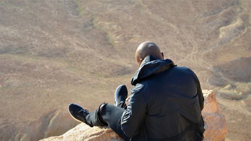 Rear view of man climbing on mountain