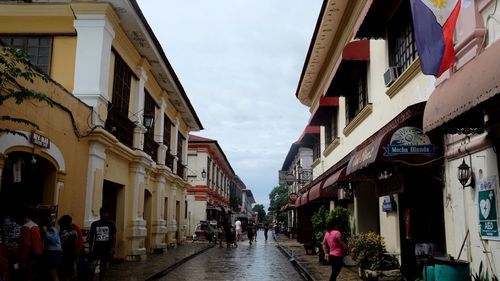 People walking on street amidst buildings in city