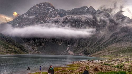 People on mountain against sky