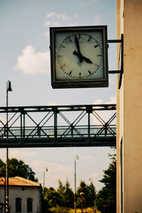 Low angle view of clock against sky