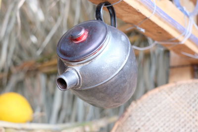 Close-up of kettle hanging from wood