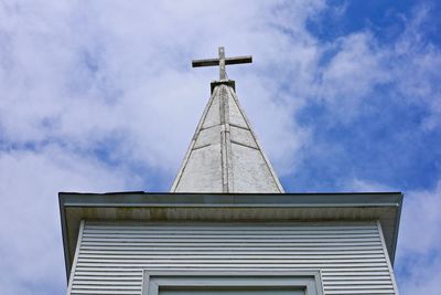 Low angle view of cross on building against sky