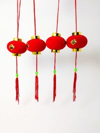 Close-up of red lanterns hanging on white background
