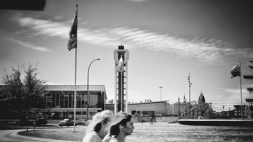 Man and woman in city against sky