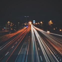 Light trails on road against sky at night