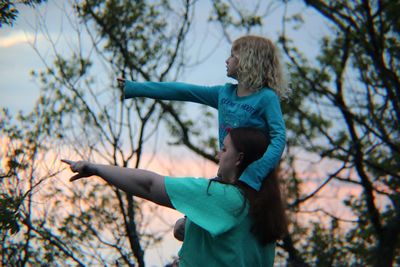 Side view of woman standing on tree