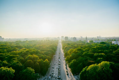 Aerial view of highway amidst trees against clear sky