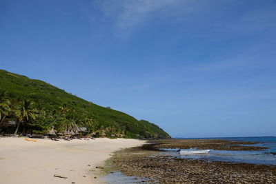 Scenic view of beach against blue sky