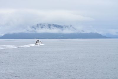 Boat sailing on sea against sky