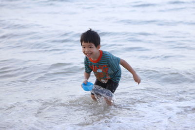 Full length portrait of happy boy on beach