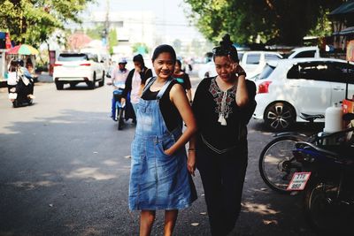 Portrait of women standing on road in city