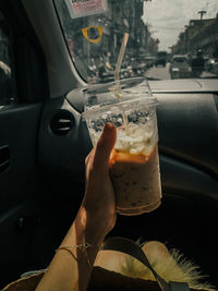 Close-up of hand holding glass of car