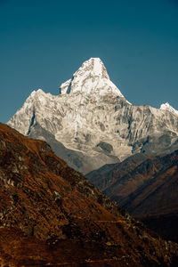 Scenic view of snowcapped mountains against clear blue sky