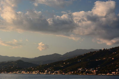 Scenic view of sea and mountains against sky