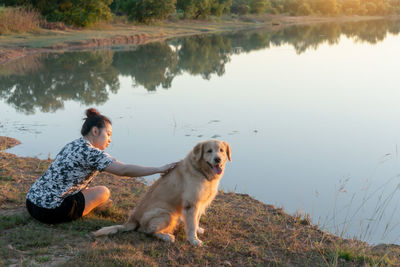 Reflection of man with dog on lake