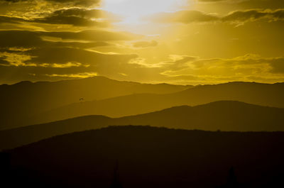Scenic view of silhouette mountains against sky during sunset