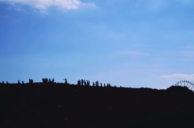 Silhouette landscape against blue sky