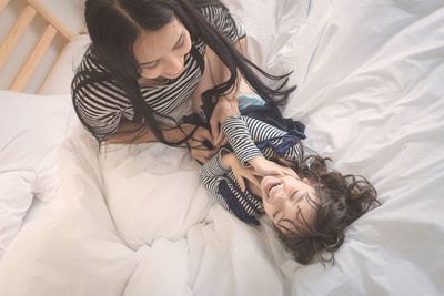 High angle view of woman with daughter on bed at home