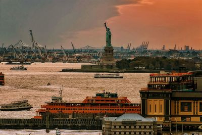 Statue of liberty amidst sea against sky during sunset
