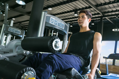 Low angle view of young man exercising in gym