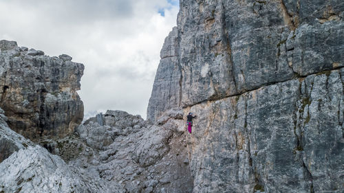 Low angle view of man climbing on rock formation