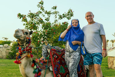 Portrait of smiling family standing against clear sky