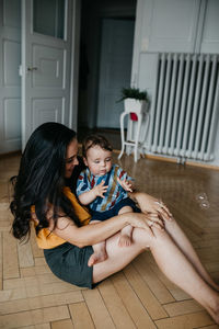 Mother and daughter sitting on floor at home