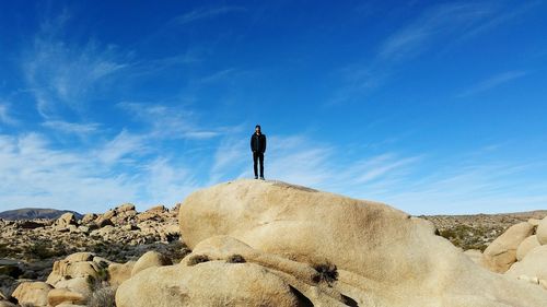 Low angle view of man standing on rock