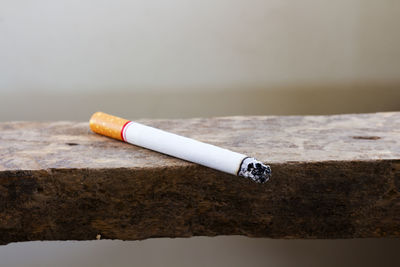 Close-up of lit cigarette on table