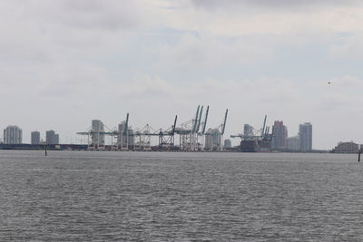 Commercial dock by sea against sky in city