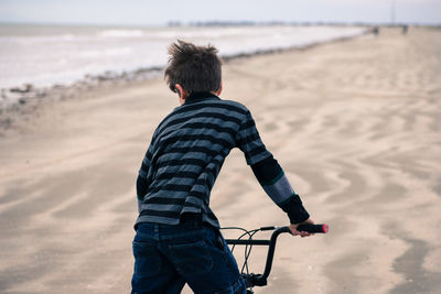 Rear view of boy on beach