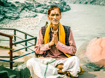 Portrait of smiling man sitting on beach