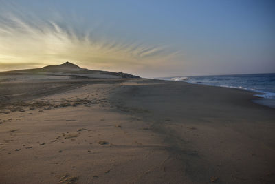 Scenic view of beach against sky during sunset