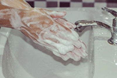 Close-up of hand holding ice cream in bathroom