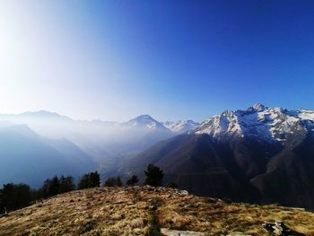 Scenic view of snowcapped mountains against clear blue sky