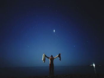 Low angle view of person standing on field against sky
