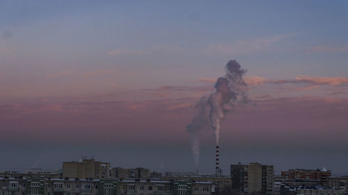 Smoke emitting from chimney against sky at sunset