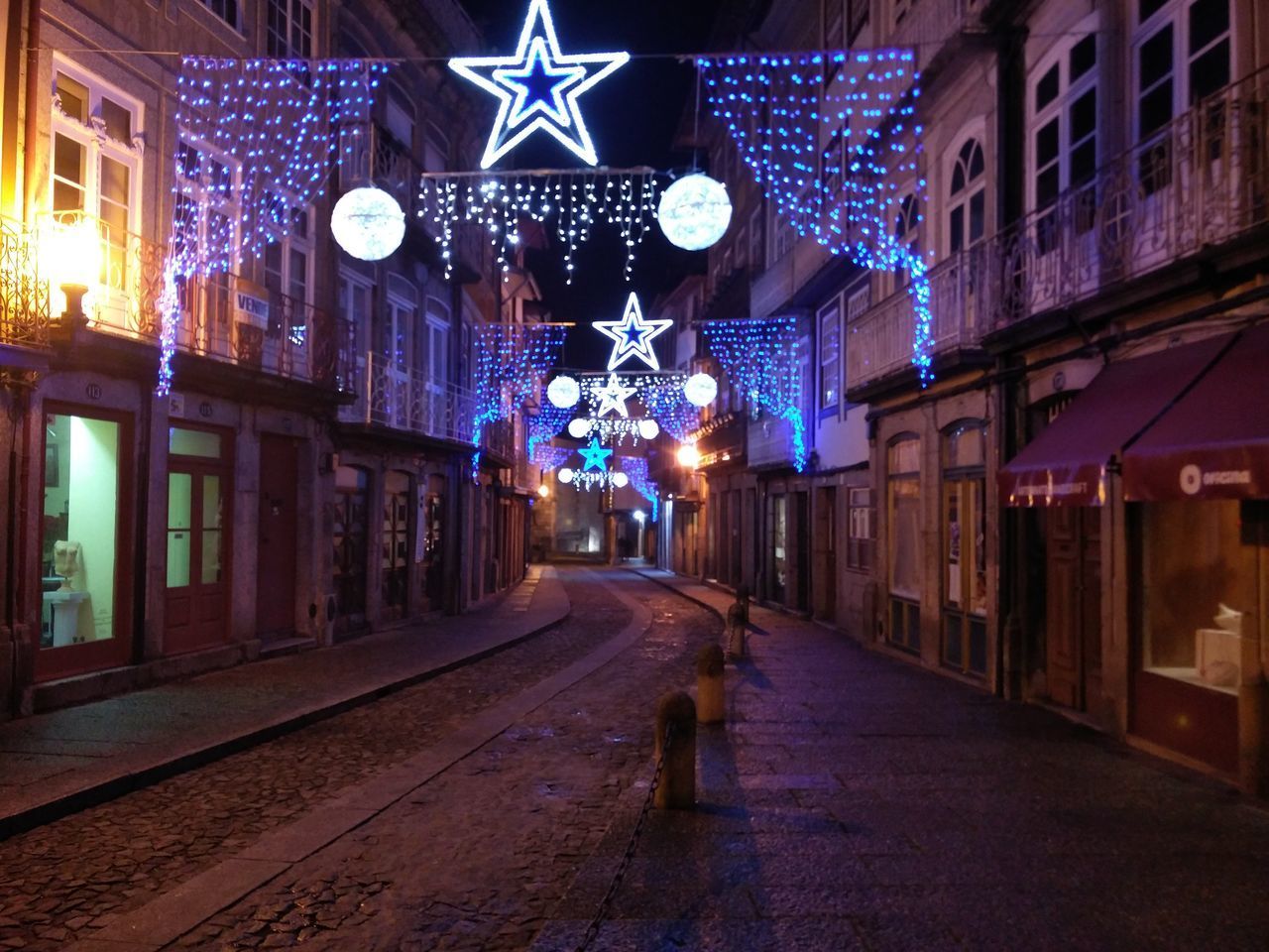 ILLUMINATED STREET AMIDST BUILDINGS