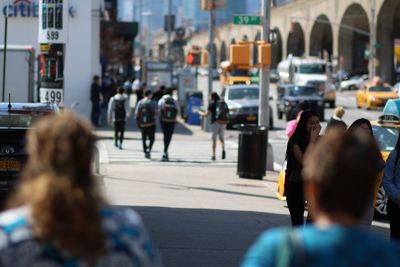 Tilt shift image of people on sidewalk in city