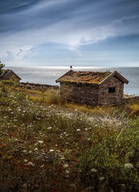 Abandoned house on field against sky