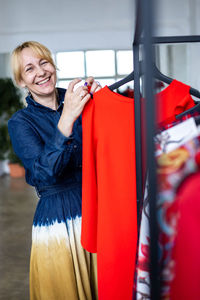 Woman standing by clothes rack
