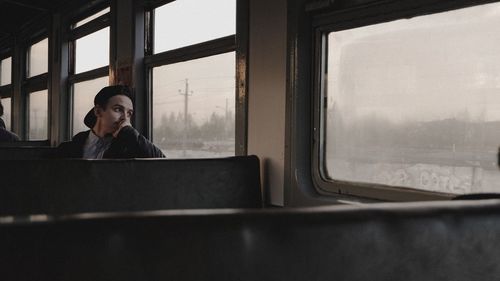 Man looking through train window