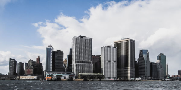 Sea by cityscape against sky