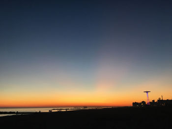 Scenic view of beach against clear sky during sunset