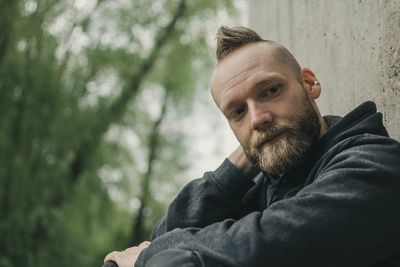 Portrait of man with spiky hair against wall