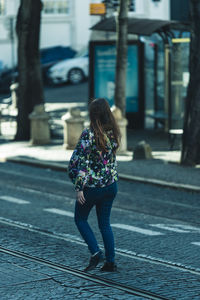 Rear view of woman walking on street in city