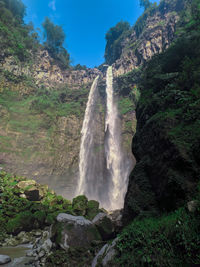 Low angle view of waterfall on rocks