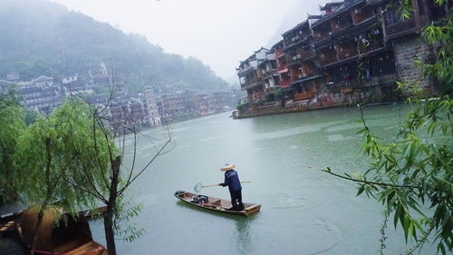 Man working on boat against clear sky